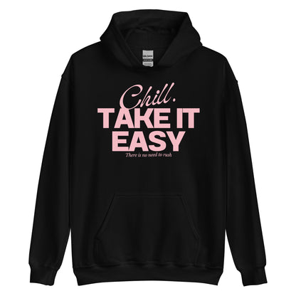 Black hoodie on a neutral backdrop, showcasing a pink-colored inspirational slogan 'Chill. TAKE IT EASY. There is no need to rush' across the chest.