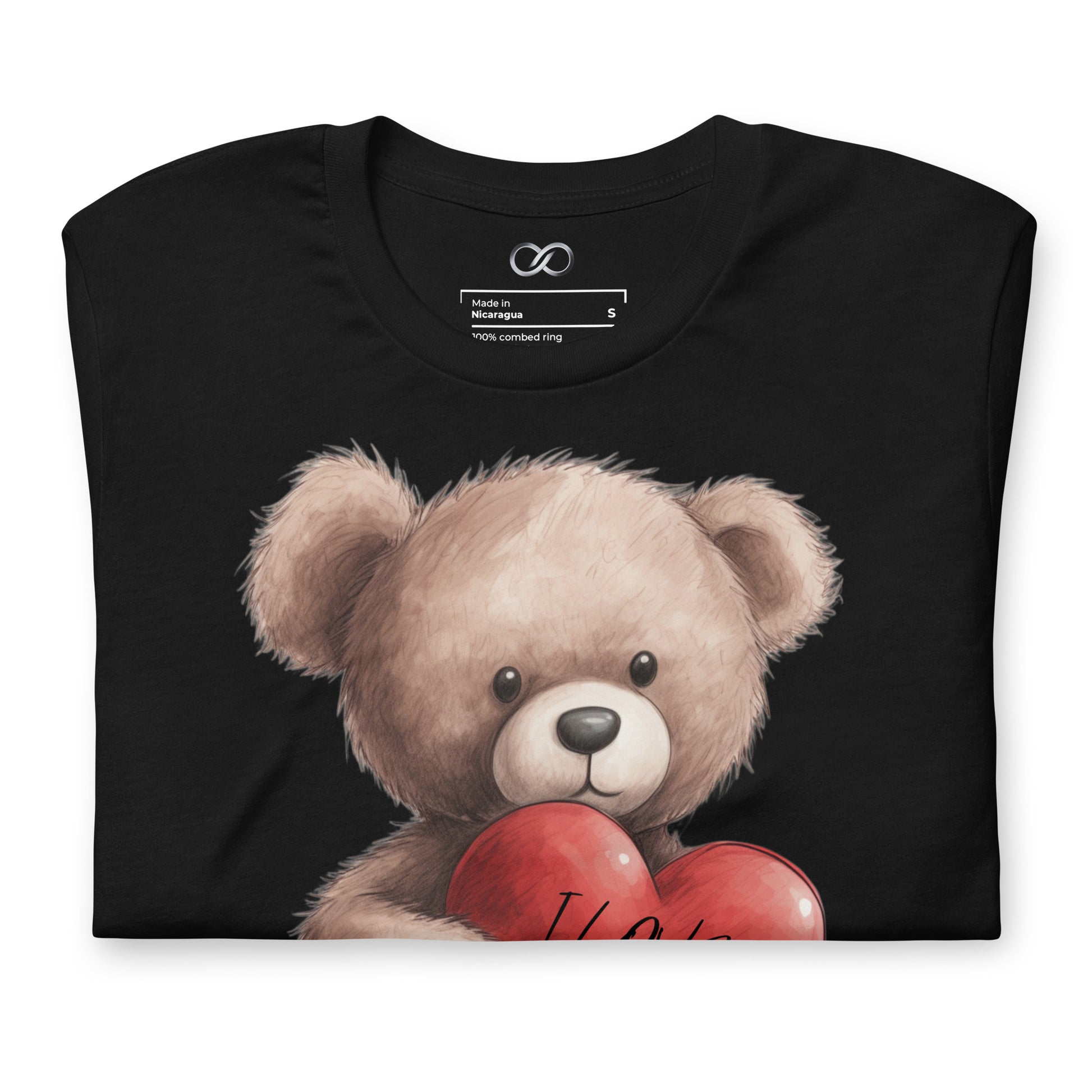 Close-up of a black t-shirt with a detailed graphic of a teddy bear holding a red heart with 'I Love You' written on it, set against a black fabric background.