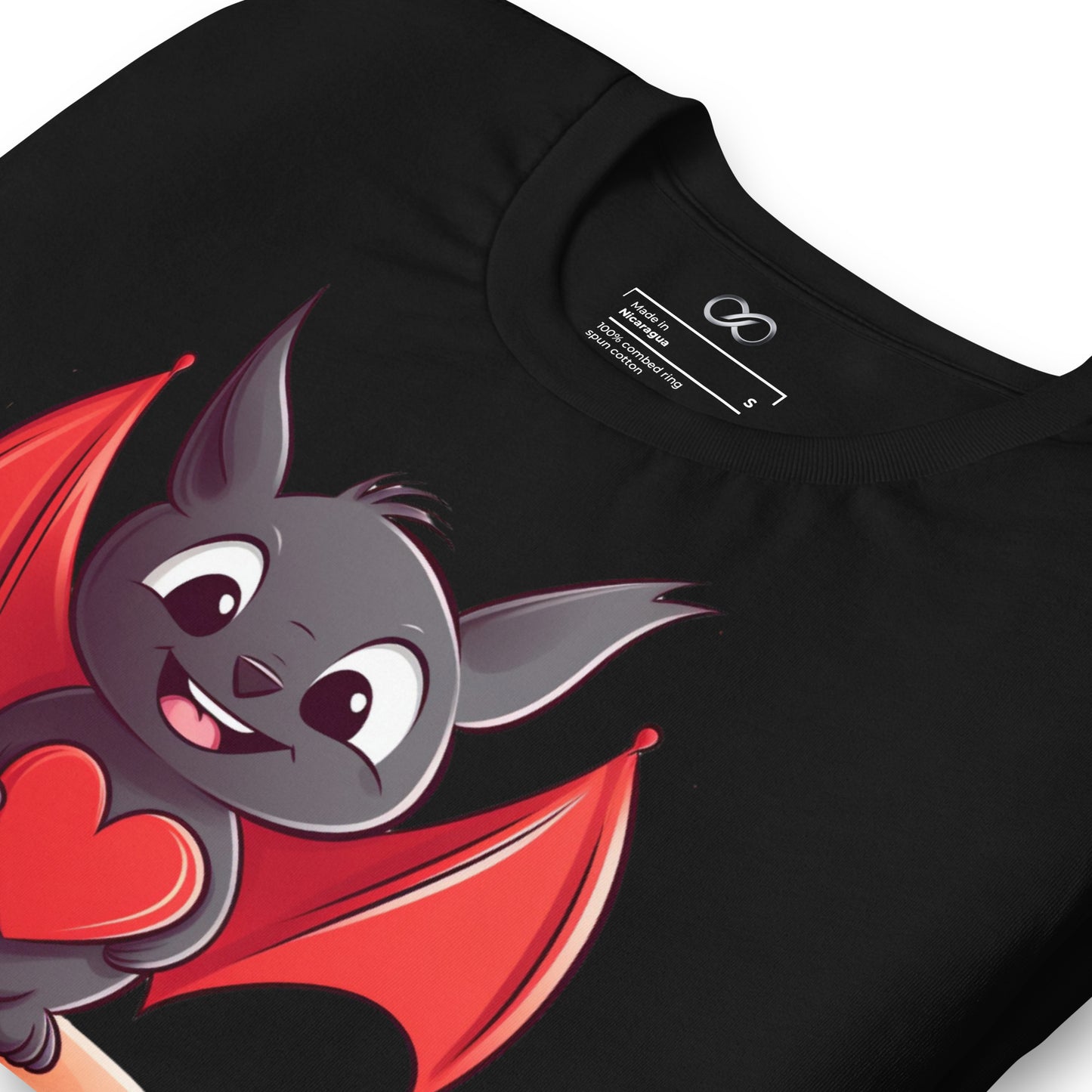 Zoomed-in view of a black t-shirt featuring a cute cartoon bat character with red wings holding a heart, emphasizing the graphic detail on the fabric.